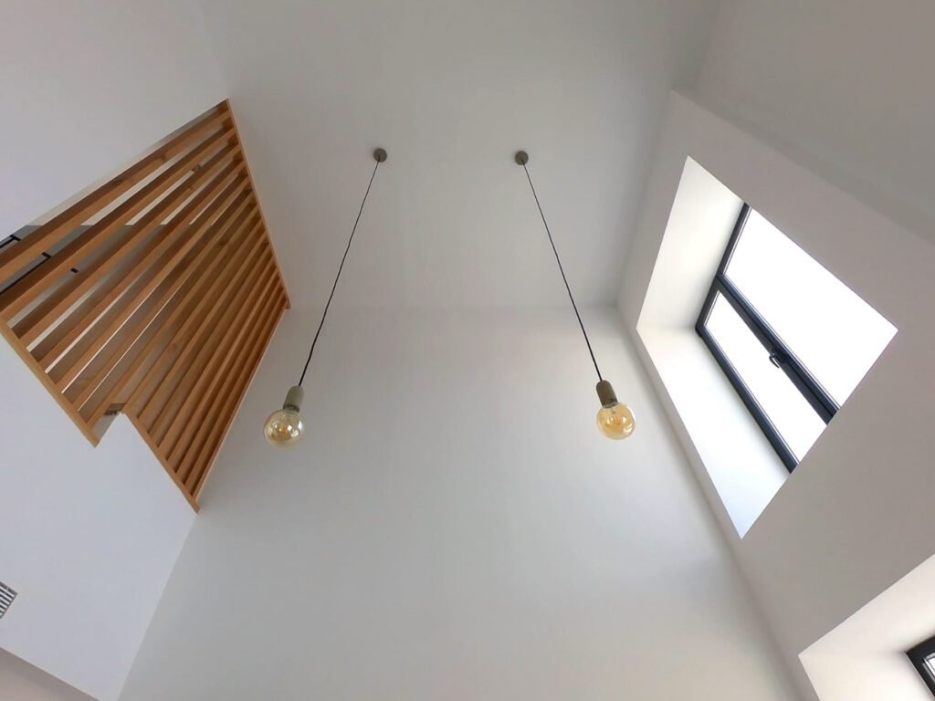 Vista del techo de una casa moderna con luces colgantes y ventanales en Almería, diseñada por MCR Arquitectos.